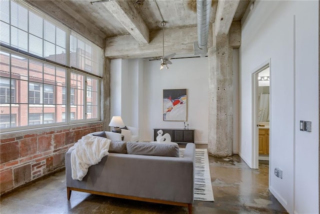 living area featuring unfinished concrete floors, healthy amount of natural light, and a ceiling fan