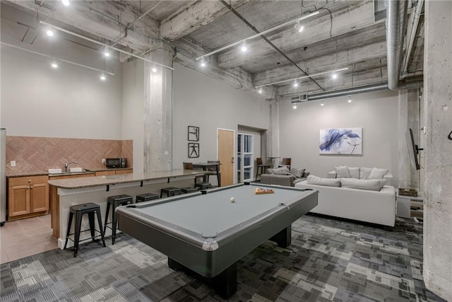 rec room with a high ceiling, billiards table, and light carpet
