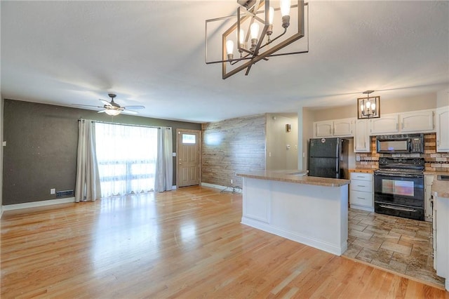 11205 E 49th St, Kansas City, MO 64133 - kitchen with black appliances, a chandelier, white cabinets, open floor plan, and backsplash