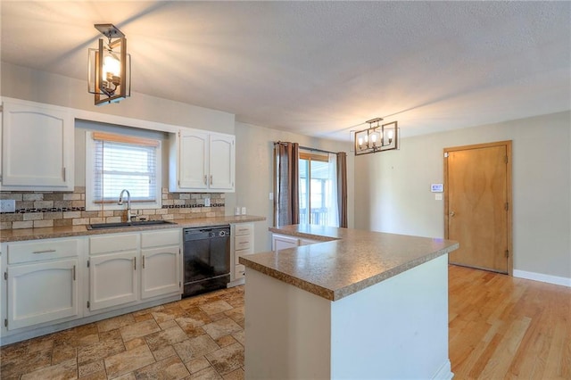 11205 E 49th St, Kansas City, MO 64133 - kitchen featuring a sink, dishwasher, a chandelier, white cabinets, and decorative backsplash