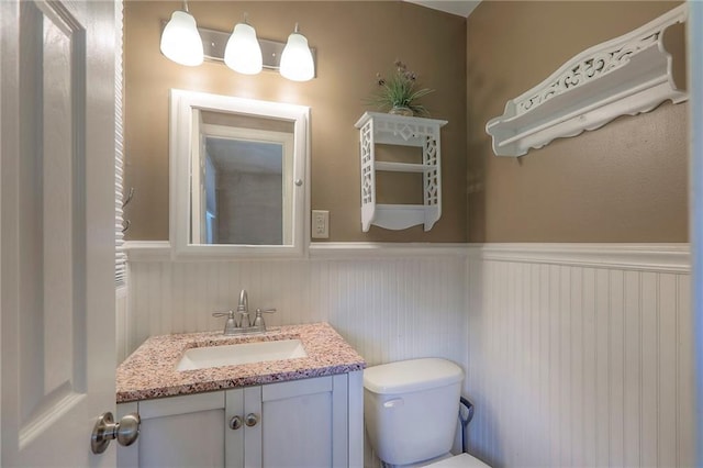 11205 E 49th St, Kansas City, MO 64133 - bathroom with wainscoting, toilet, and vanity