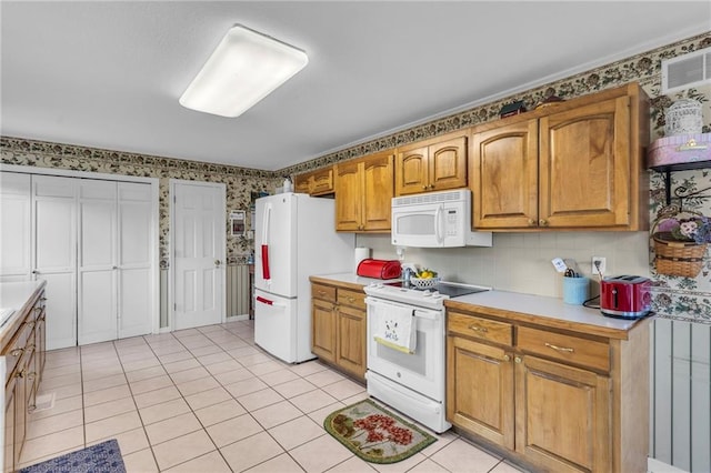 1758 Labette Rd, Ottawa, KS 66067 - kitchen with white appliances, light countertops, light tile patterned flooring, brown cabinets, and wallpapered walls