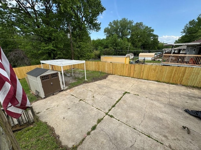 1606 N Ponca Dr, Independence, MO 64058 - view of patio with a storage unit, a fenced backyard, and an outdoor structure