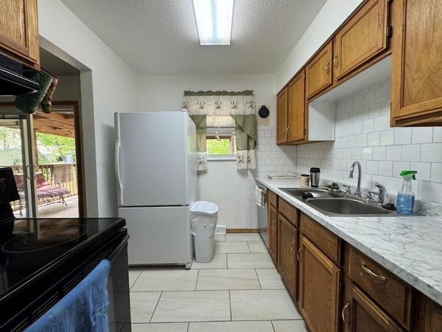 1606 N Ponca Dr, Independence, MO 64058 - kitchen featuring freestanding refrigerator, black electric range oven, a sink, brown cabinets, and stainless steel dishwasher