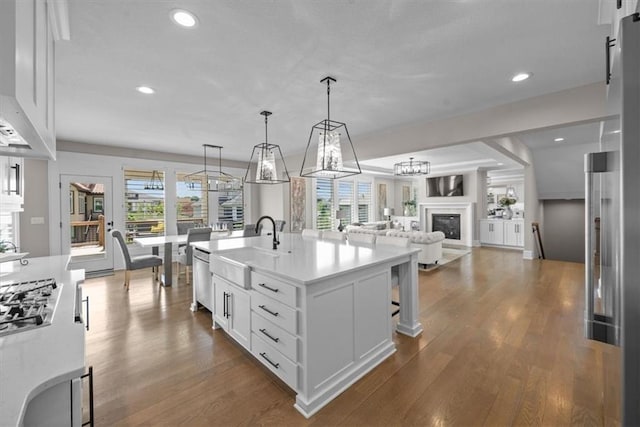 15624 Delmar St, Overland Park, KS 66224 - kitchen featuring a sink, dark wood finished floors, white cabinets, a glass covered fireplace, and recessed lighting