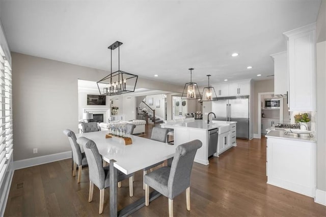 15624 Delmar St, Overland Park, KS 66224 - dining room with a fireplace, stairs, recessed lighting, dark wood-type flooring, and baseboards