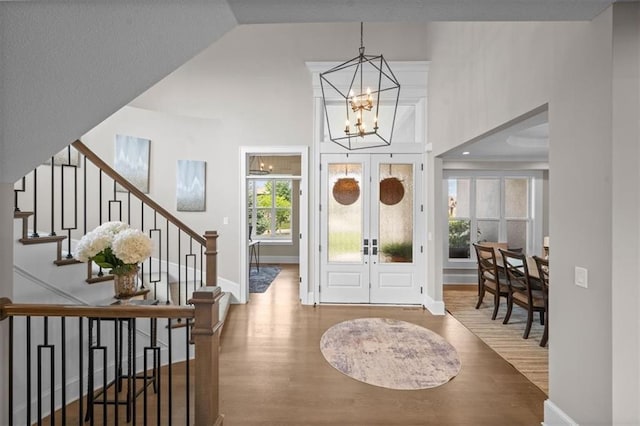 15624 Delmar St, Overland Park, KS 66224 - entrance foyer with wood finished floors, french doors, a chandelier, stairs, and baseboards