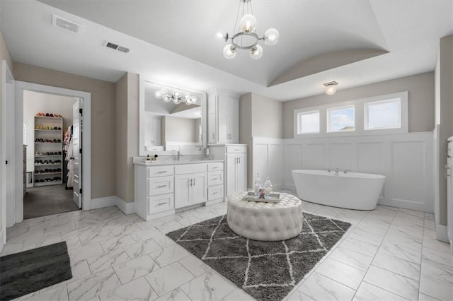 15624 Delmar St, Overland Park, KS 66224 - bathroom with marble look tiles, vanity, a freestanding tub, a chandelier, and a wainscoted wall
