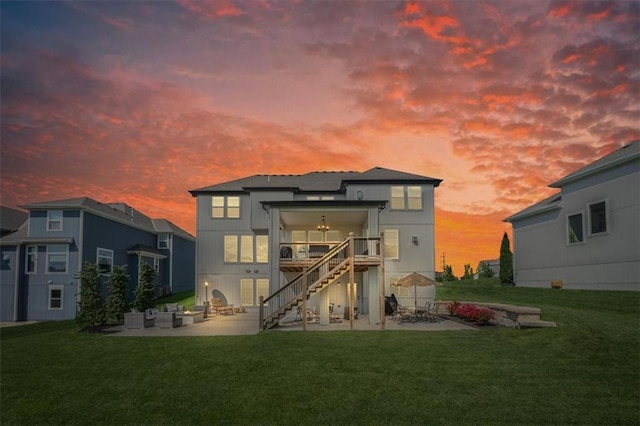 15624 Delmar St, Overland Park, KS 66224 - back of property at dusk with a patio area, stairs, a lawn, a deck, and an outdoor hangout area
