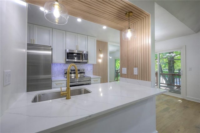 12136 Hayes St, Overland Park, KS 66213 - kitchen with appliances with stainless steel finishes, a sink, white cabinets, decorative backsplash, and light stone countertops