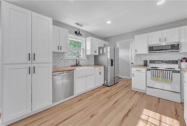 252 SE 23rd Hwy, Knob Noster, MO 65336 - kitchen with appliances with stainless steel finishes, light wood-style floors, light countertops, white cabinetry, and recessed lighting