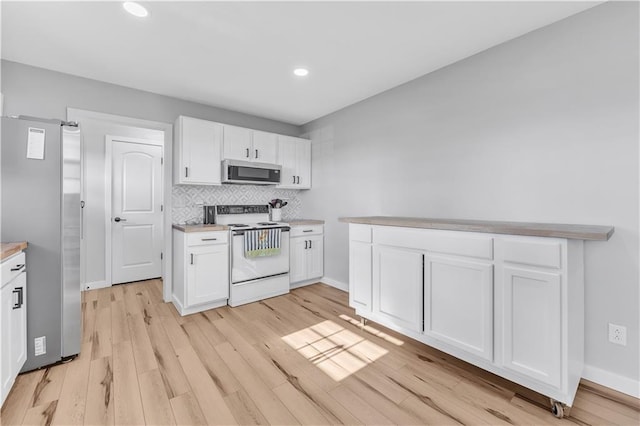 252 SE 23rd Hwy, Knob Noster, MO 65336 - kitchen featuring appliances with stainless steel finishes, white cabinets, light wood finished floors, light countertops, and tasteful backsplash