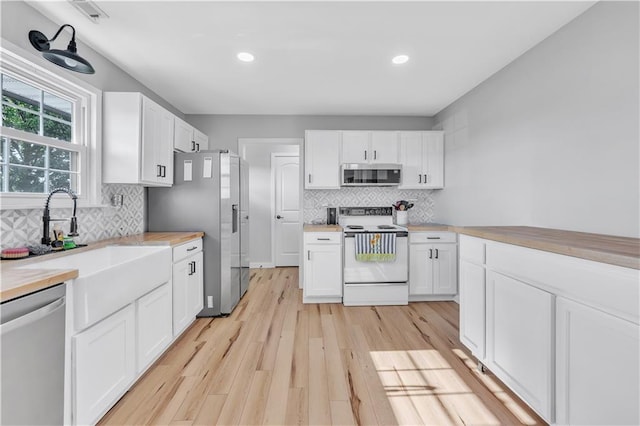 252 SE 23rd Hwy, Knob Noster, MO 65336 - kitchen with appliances with stainless steel finishes, white cabinets, backsplash, recessed lighting, and light wood-style flooring