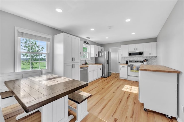 252 SE 23rd Hwy, Knob Noster, MO 65336 - kitchen featuring stainless steel appliances, tasteful backsplash, white cabinetry, recessed lighting, and light wood-type flooring