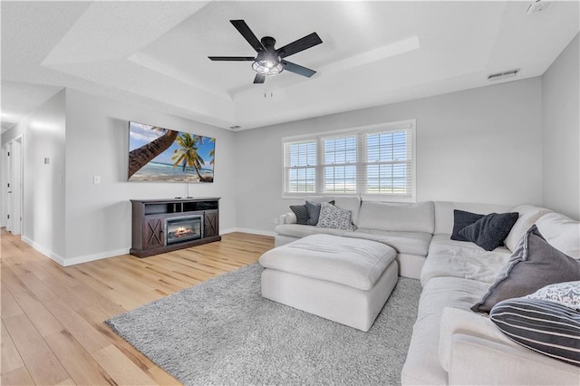 252 SE 23rd Hwy, Knob Noster, MO 65336 - living area featuring a raised ceiling, light wood finished floors, a ceiling fan, and baseboards