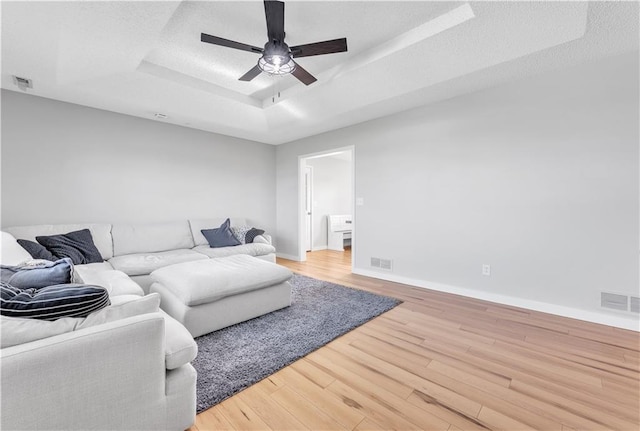 252 SE 23rd Hwy, Knob Noster, MO 65336 - living room featuring a raised ceiling, a ceiling fan, light wood-style flooring, and baseboards