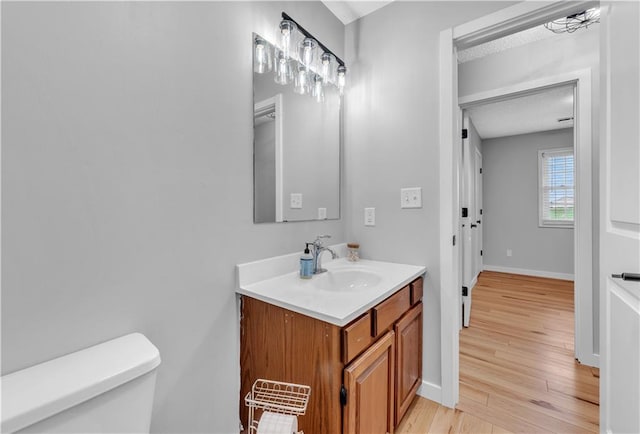 252 SE 23rd Hwy, Knob Noster, MO 65336 - bathroom featuring wood finished floors, toilet, vanity, and baseboards