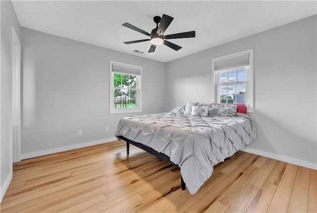 252 SE 23rd Hwy, Knob Noster, MO 65336 - bedroom featuring light wood-style flooring, baseboards, a ceiling fan, and a textured ceiling