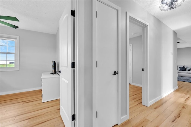 252 SE 23rd Hwy, Knob Noster, MO 65336 - hallway featuring light wood finished floors, baseboards, and a textured ceiling