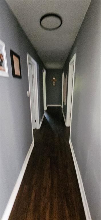 708 S Gay St, Holden, MO 64040 - corridor with wood finished floors, baseboards, and a textured ceiling