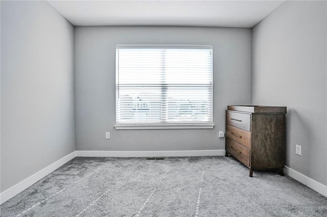 unfurnished bedroom with carpet, baseboards, and multiple windows