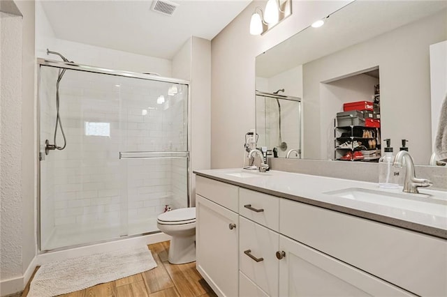 full bath with wood finished floors, a stall shower, and double vanity