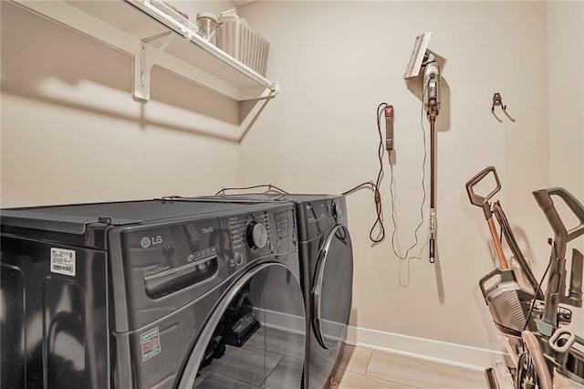 laundry area with washing machine and dryer and baseboards