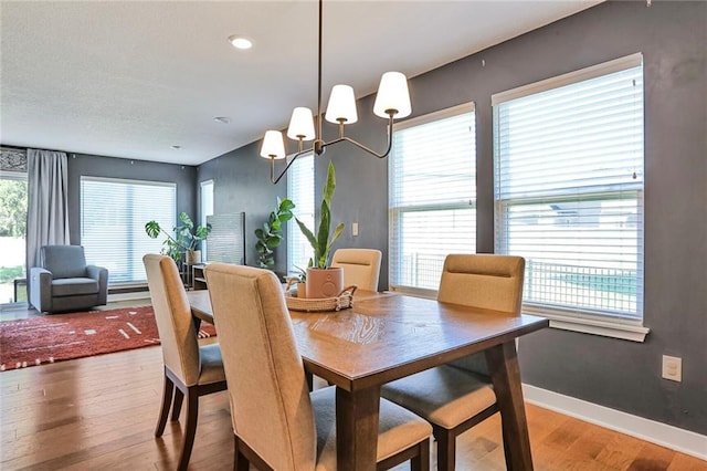 dining area with wood finished floors, a chandelier, and baseboards