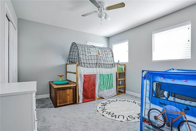 carpeted bedroom featuring baseboards and a ceiling fan