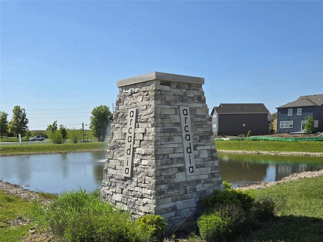 community / neighborhood sign with a water view