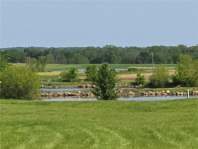 surrounding community with a water view and a yard
