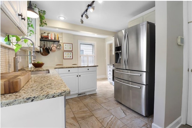 23 W Winthrope Rd, Kansas City, MO 64113 - kitchen with stainless steel fridge, a peninsula, a sink, baseboards, and white cabinets