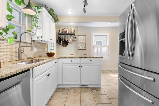 23 W Winthrope Rd, Kansas City, MO 64113 - kitchen with appliances with stainless steel finishes, a sink, a peninsula, tasteful backsplash, and white cabinetry