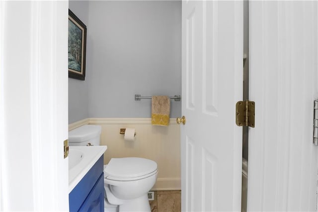 23 W Winthrope Rd, Kansas City, MO 64113 - bathroom with toilet, vanity, a wainscoted wall, and tile patterned flooring