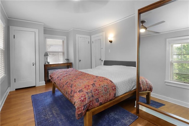 23 W Winthrope Rd, Kansas City, MO 64113 - bedroom with wood finished floors, ornamental molding, baseboards, two closets, and a ceiling fan
