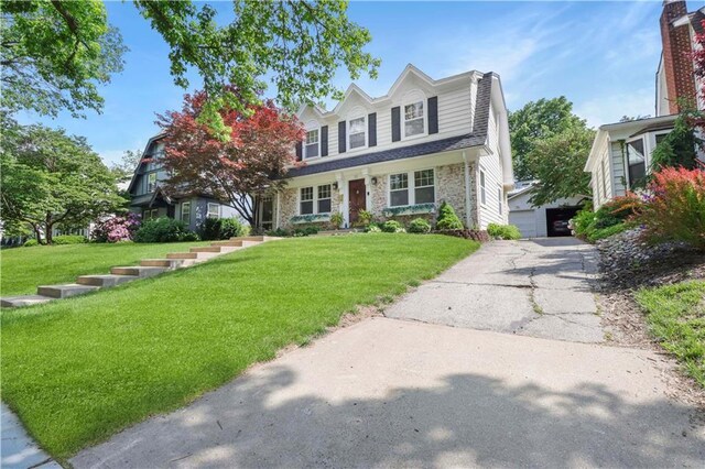 23 W Winthrope Rd, Kansas City, MO 64113 - view of front of home featuring an outdoor structure, a front lawn, and brick siding
