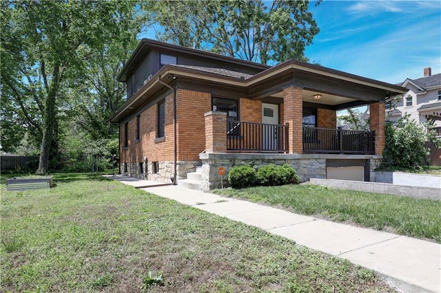 2414 N 12th St, Kansas City, KS 66104 - view of front of house featuring brick siding, a front yard, a porch, and a garage
