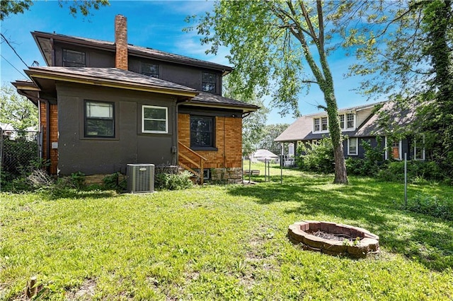 2414 N 12th St, Kansas City, KS 66104 - back of house featuring a fire pit, cooling unit, and a chimney