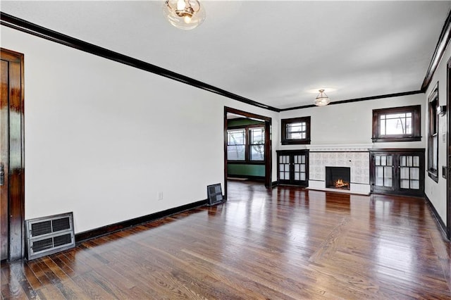 2414 N 12th St, Kansas City, KS 66104 - unfurnished living room with ornamental molding, wood finished floors, baseboards, a fireplace, and heating unit