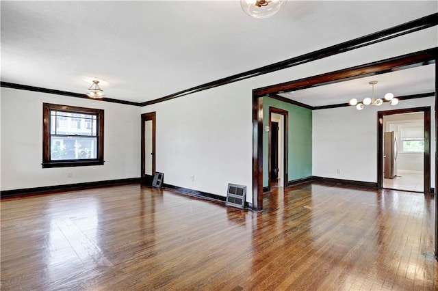 2414 N 12th St, Kansas City, KS 66104 - spare room featuring crown molding, wood-type flooring, a chandelier, and baseboards