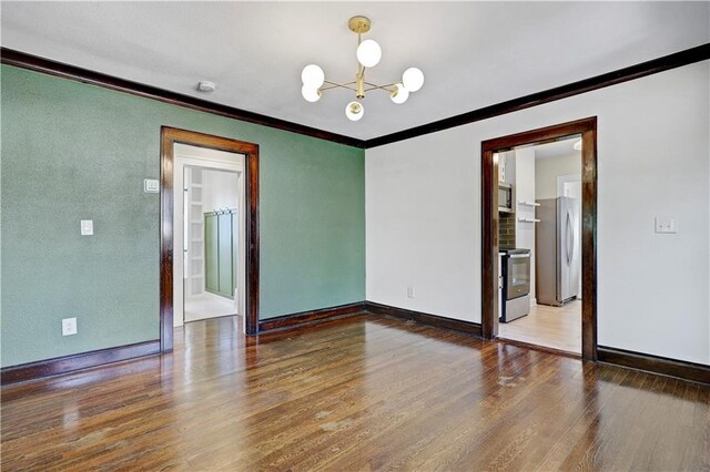 2414 N 12th St, Kansas City, KS 66104 - unfurnished room with crown molding, wood finished floors, a chandelier, and baseboards