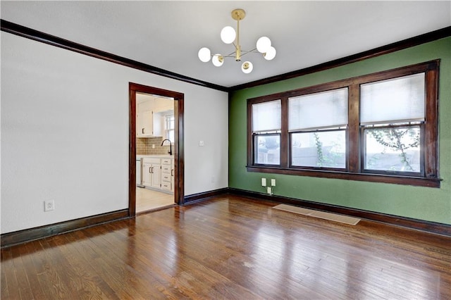 2414 N 12th St, Kansas City, KS 66104 - unfurnished room with ornamental molding, a chandelier, a sink, wood finished floors, and baseboards