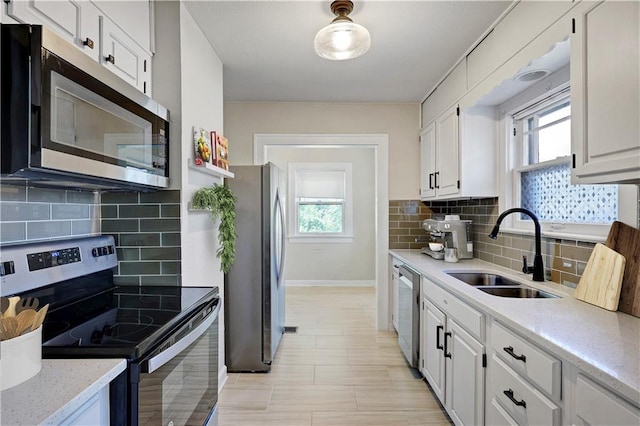 2414 N 12th St, Kansas City, KS 66104 - kitchen featuring stainless steel appliances, a sink, white cabinets, and plenty of natural light