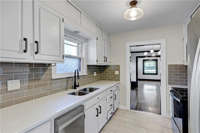 2414 N 12th St, Kansas City, KS 66104 - kitchen with stainless steel appliances, a sink, white cabinetry, and plenty of natural light