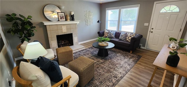 7934 Hemlock St, Overland Park, KS 66204 - living room with wood finished floors, healthy amount of natural light, a tiled fireplace, and baseboards