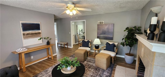 7934 Hemlock St, Overland Park, KS 66204 - living area featuring ceiling fan, wood finished floors, a textured ceiling, baseboards, and a tile fireplace