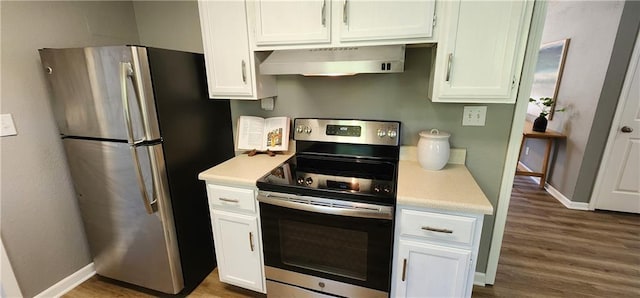 7934 Hemlock St, Overland Park, KS 66204 - kitchen featuring appliances with stainless steel finishes, wall chimney range hood, light countertops, and white cabinets