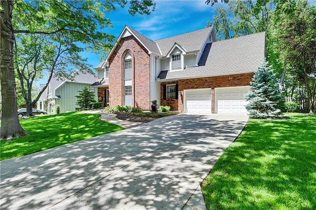 traditional-style house featuring brick siding, concrete driveway, a front yard, and an attached garage