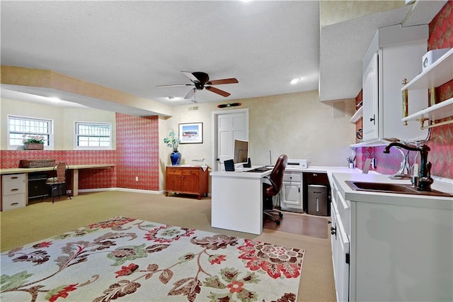 office with a sink, light colored carpet, wallpapered walls, ceiling fan, and a textured ceiling