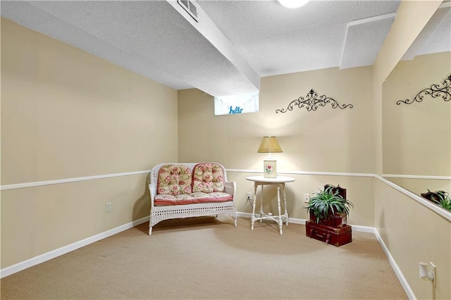 living area with carpet floors, a textured ceiling, and baseboards